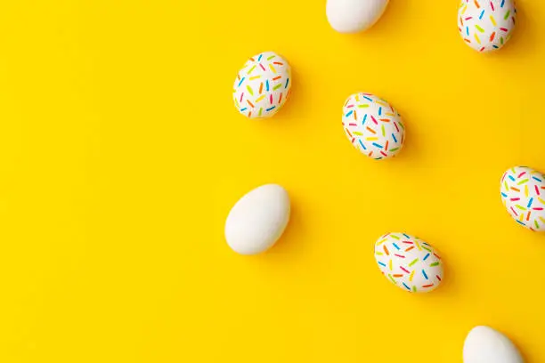 Photo of Sprinkle painted easter eggs on yellow background