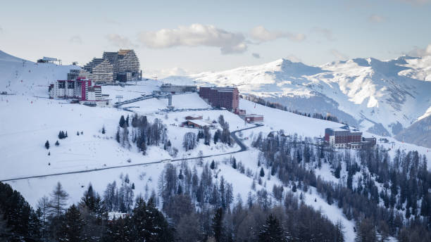 View of La Plagne Aime 2000 ski resort in French Savoy Alps. Snow covered mountains and buildings of ski apartments View of La Plagne Aime 2000 ski resort in French Savoy Alps. Snow covered mountains and buildings of ski apartments la plagne photos stock pictures, royalty-free photos & images