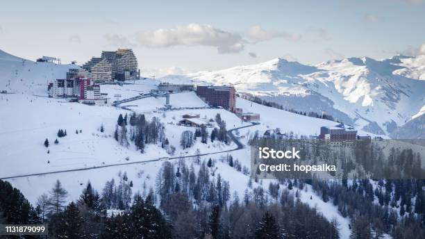 View Of La Plagne Aime 2000 Ski Resort In French Savoy Alps Snow Covered Mountains And Buildings Of Ski Apartments Stock Photo - Download Image Now