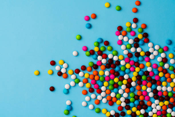 istock Colourful chocolate bean candies on blue background 1131880215