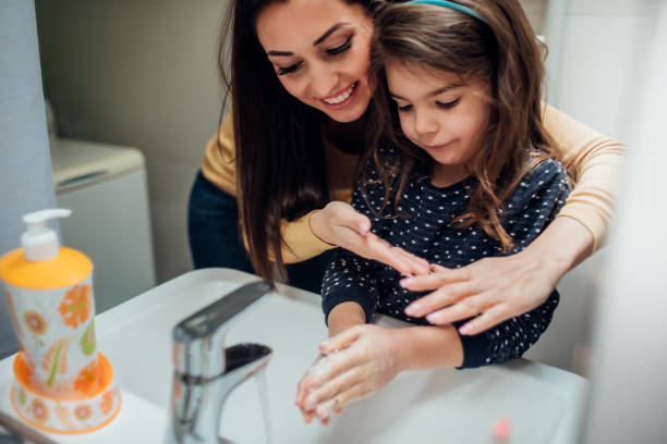 mutter und tochter waschen hände - mirror mother bathroom daughter stock-fotos und bilder