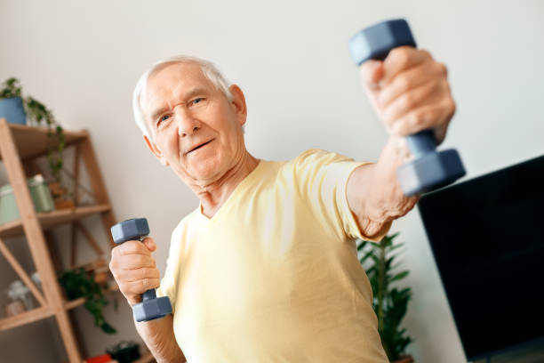 istock Senior man exercise at home health care with dumbbells front view 1131882968