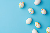 Sprinkle painted colourful easter eggs on blue background