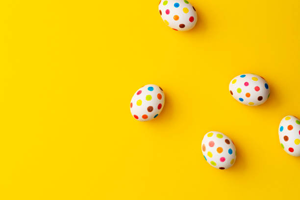 Spotty painted colourful easter eggs on yellow background. stock photo