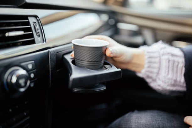 istock cup holder in the car. female hand with coffee on a trip. 1131883706