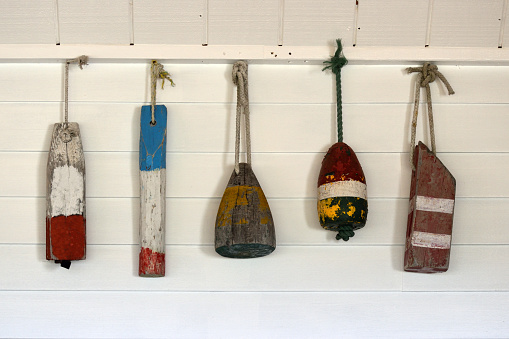 Old Decorative Buoys Hanging on a White Wooden Wall