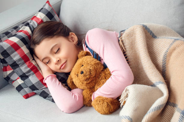 istock Little girl at home lying with teddy sleeping relaxed 1131887661