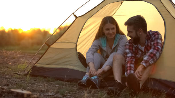 istock Cheerful hikers tying shoelaces, ready for long walk in comfortable sneakers 1131888600