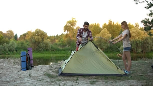 istock Couple putting up dome tent, wilderness survival training, essential skills 1131888609