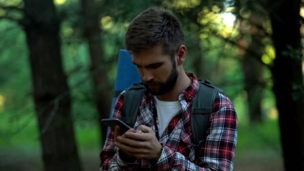istock Disoriented camper searching for map in smartphone, geocaching and orienteering 1131888790