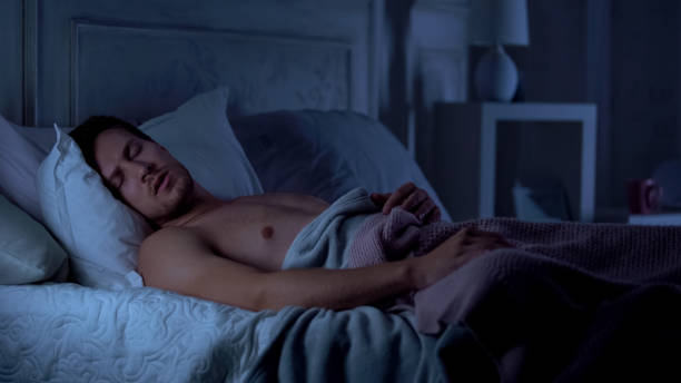 istock Handsome male sleeping in bed and snoring, resting after hard day, bad sleep 1131888872