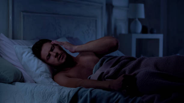 istock Sleepy man having strong headache, rubbing temples, sleepless night, migraine 1131888970