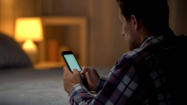 istock Young man sitting scrolling smartphone searching video in application, leisure 1131889125