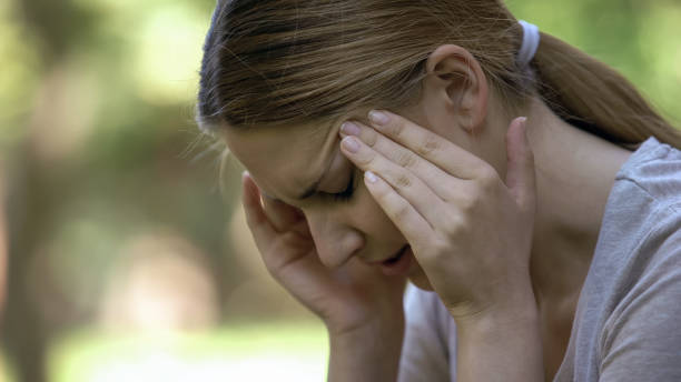 young woman suffering acute headache, worrying about failures, stressful day - anemia imagens e fotografias de stock