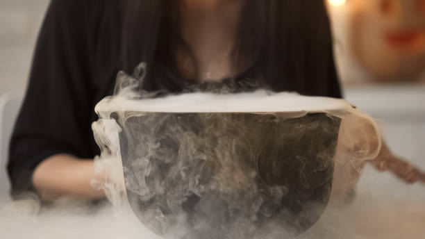 istock Witch conjuring, putting magic spell and cooking potion in pot with white smoke 1131890069
