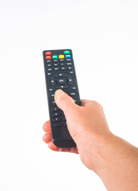 istock hand holding a remote control on white background, close-up 1131890379