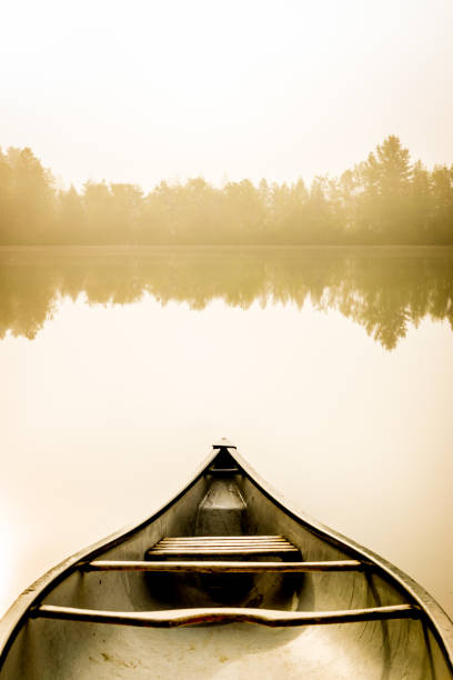peaceful fishing lake and canoe at sunrise. - rowboat river lake nautical vessel imagens e fotografias de stock