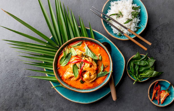 thai shrimps red curry. thailändische tradition rote curry-suppe mit garnelen und kokosmilch. panaeng curry in blauer platte auf grauem hintergrund - suppe fotos stock-fotos und bilder
