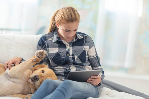 istock Girl on her tablet pets her dog 1131900612