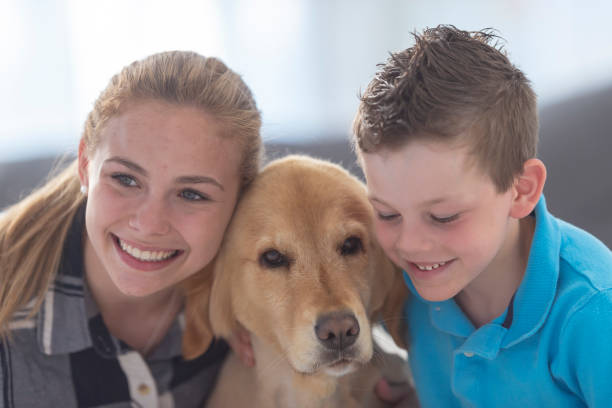 istock Brother and sister cuddle with their dog 1131900613