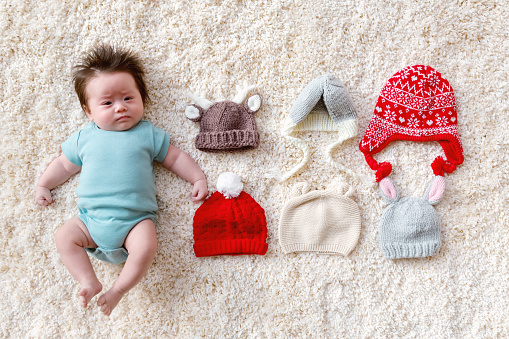 Newborn baby boy with assorted baby knitted hats