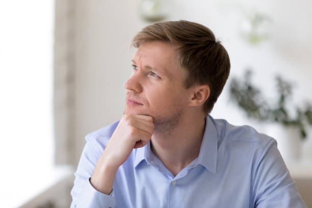 istock Thoughtful businessman sitting at workplace looking away 1131900940