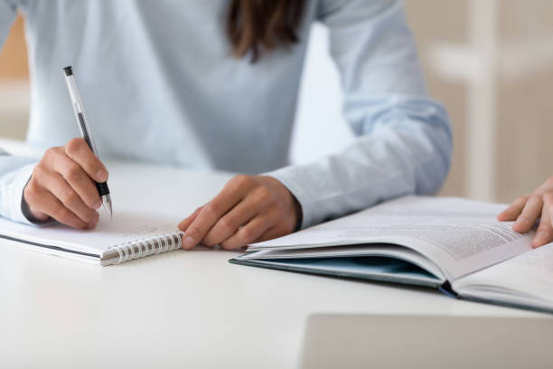 istock Closeup female hand writing in notepad studying together with male 1131900982