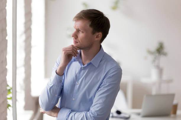 istock Serious businessman standing in office room thinking making a decision 1131900993