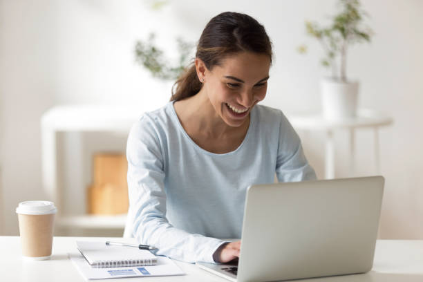 istock Cheerful mixed race female smiling typing on computer 1131900997