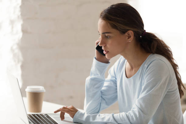 istock Mixed race serious female browsing internet talking on mobile phone 1131901000