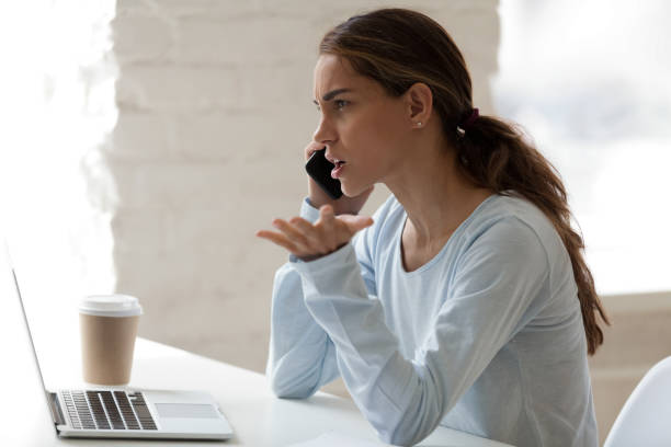 mujer estresada tiene una conversación telefónica desagradable - arguing complaining women conflict fotografías e imágenes de stock