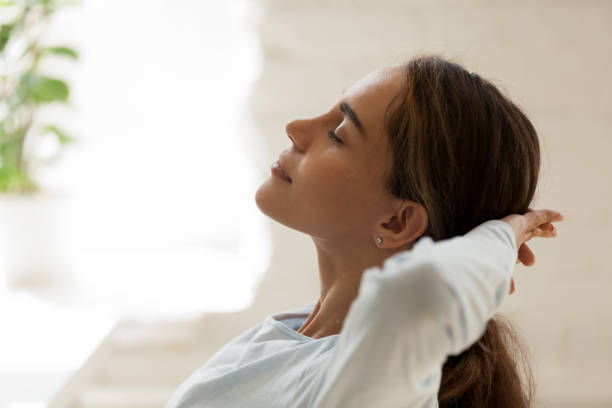 istock Female with closed eyes putting hands behind head resting 1131901013