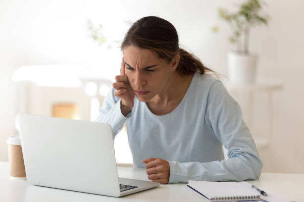 Young woman with poor vision looking at computers screen Mixed race woman with poor vision working on computer having problems difficulties with reading on device. Long use of modern technologies without breaks impairing eyesight and overall health concept squint eyes stock pictures, royalty-free photos & images