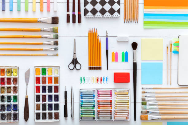 istock Supplies set on desk top view, creative tools for school creative work on white wooden table, background with drawing painting stationery, color paints brushes pencils crayons, copy space, flat lay 1131901541