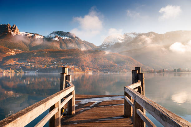 muelle de madera en el lago de annecy en invierno. montañas de los alpes, francia. - travel europe sunset winter fotografías e imágenes de stock