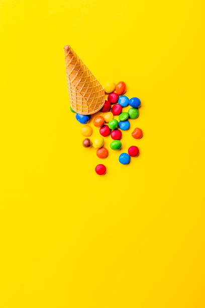 istock Ice creame cone with candy on yellow background. Minimalistic concept 1131906682