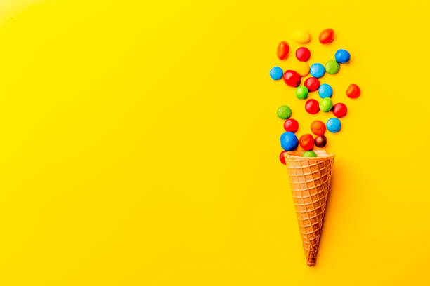 istock Ice creame cone with candy on yellow background. Minimalistic concept 1131906695
