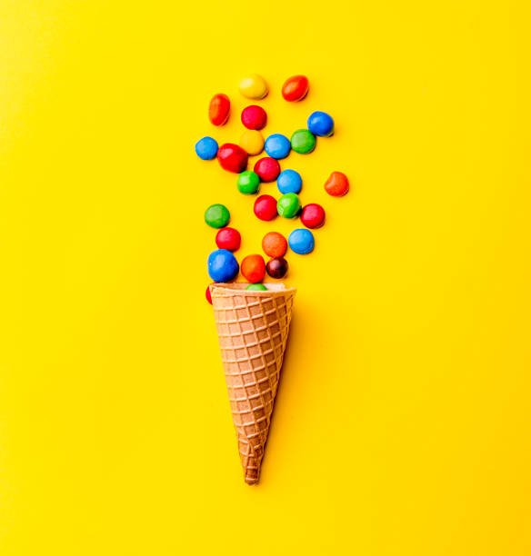 istock Ice creame cone with candy on yellow background. Minimalistic concept 1131906696