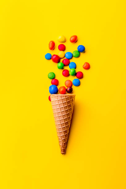 istock Ice creame cone with candy on yellow background. Minimalistic concept 1131906698
