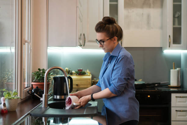 istock Girl washing dishes in kitchen 1131917043