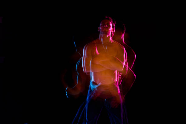 istock Shirtless man dancing with color gel lights 1131917820