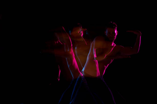 istock Shirtless man dancing with color gel lights 1131917848