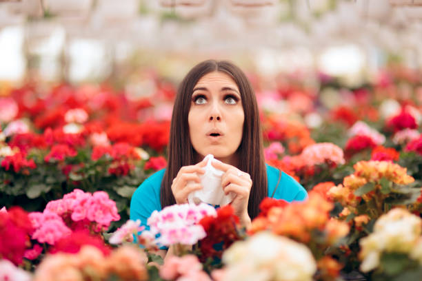 istock Woman Surrounded by Flowers Suffering from Allergies 1131919356
