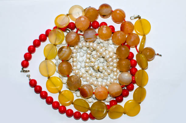 many different necklaces and jewelry on a light background