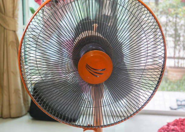 istock close up orange fan at home for cooling temperature 1131921666