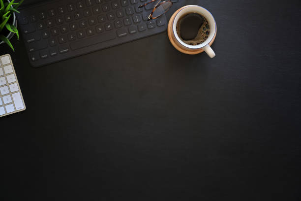 istock Office dark leather desk table with coffee, computer and office supplies. 1131932051