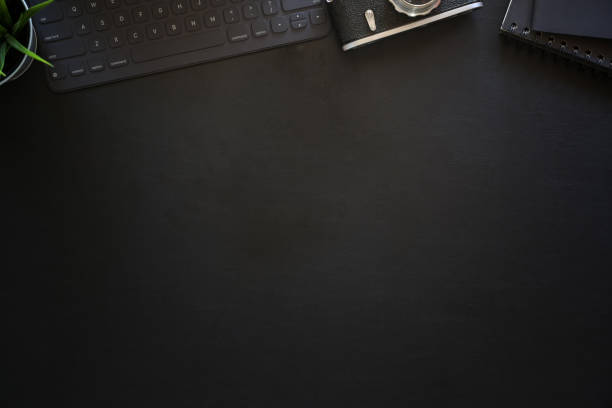 istock Dark leather office photography desk table with keyboard tablet and vintage camera 1131932052
