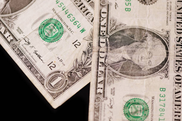 istock American dollars on a dark background. Brown color toned 1131940947