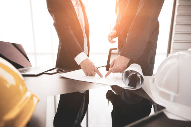 istock Businessman and engineer reviewing plan design 1131942996