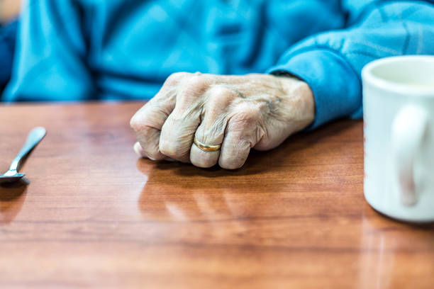 istock Elderly Man Diner's Fisted Hand Resting on Restaurant Table 1131943842